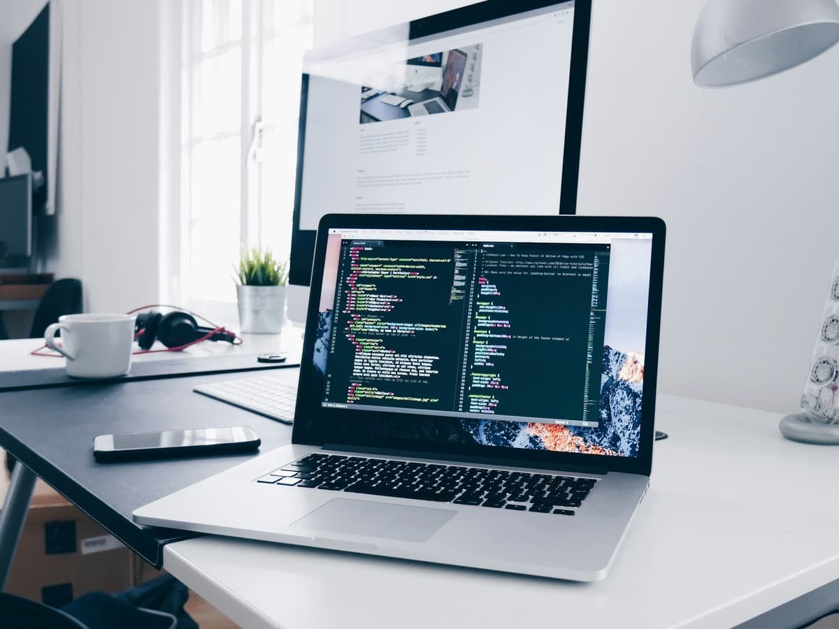 A laptop showing code on a bright desk during a website build
